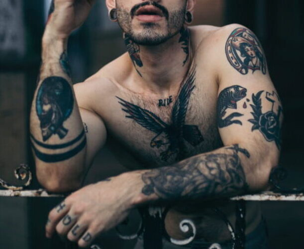 uomo con tatuaggi su petto e braccia