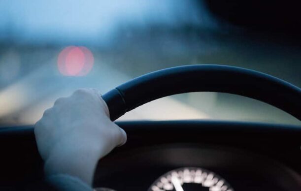 Guidare un'auto, mani sul volante di una persona alla guida della sua macchina